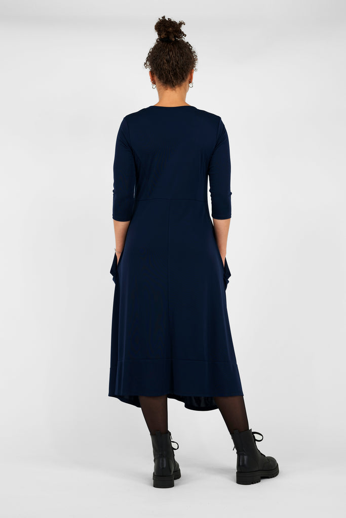 Feminin, schick, elegant aber zugleich lässig-casual.   Das Midi-Kleid aus fließendem, bi-elastischem Stoff sorgt für eine feminine Silhouette, hat aber zugleich lässige Eigenschaften: mit modisch gerafften Details unterhalb der Seitennahttaschen, weitem Rundhalsausschnitt und 3/4 Ärmeln. Hinten befindet sich eine mittige Naht, die Saumlinie vorne ist leicht abgerundet und verlängert. 