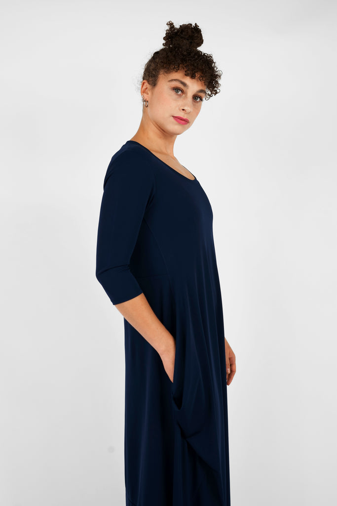 Feminin, schick, elegant aber zugleich lässig-casual.   Das Midi-Kleid aus fließendem, bi-elastischem Stoff sorgt für eine feminine Silhouette, hat aber zugleich lässige Eigenschaften: mit modisch gerafften Details unterhalb der Seitennahttaschen, weitem Rundhalsausschnitt und 3/4 Ärmeln. Hinten befindet sich eine mittige Naht, die Saumlinie vorne ist leicht abgerundet und verlängert. 